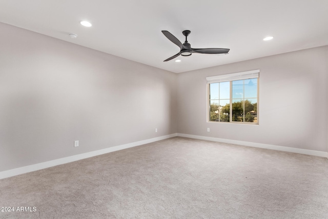 carpeted spare room featuring ceiling fan