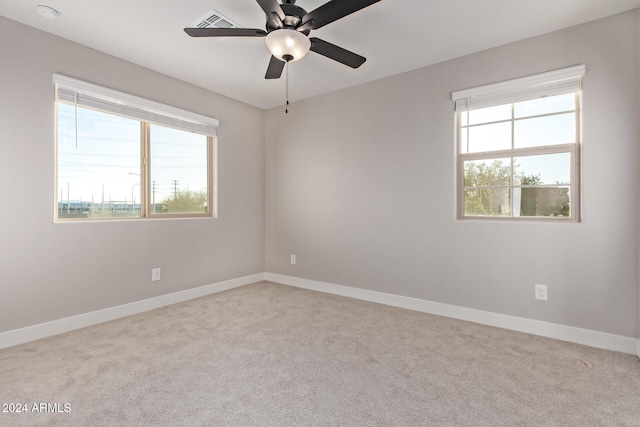 carpeted empty room featuring ceiling fan and a healthy amount of sunlight