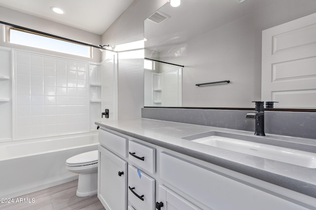 full bathroom featuring shower / bathtub combination, wood-type flooring, vanity, toilet, and lofted ceiling