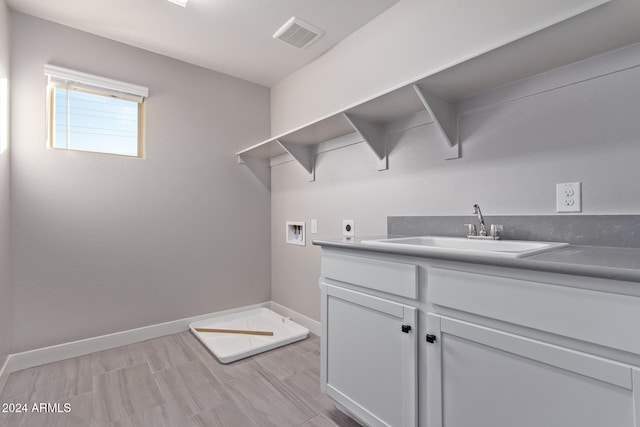 laundry area with washer hookup, electric dryer hookup, sink, and cabinets