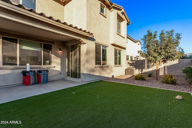 back of property featuring central AC, a patio, and a yard