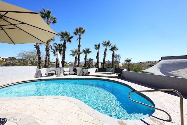 view of swimming pool featuring a patio, a fenced in pool, and an in ground hot tub