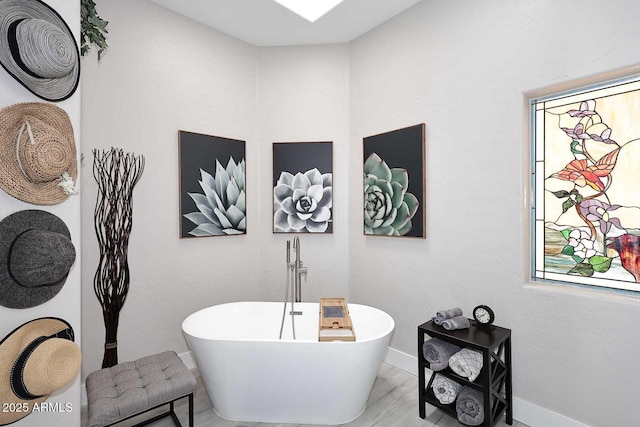 full bath featuring a soaking tub, baseboards, and wood finished floors