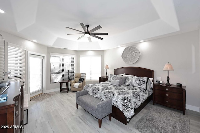 bedroom with a ceiling fan, baseboards, light wood finished floors, recessed lighting, and a raised ceiling