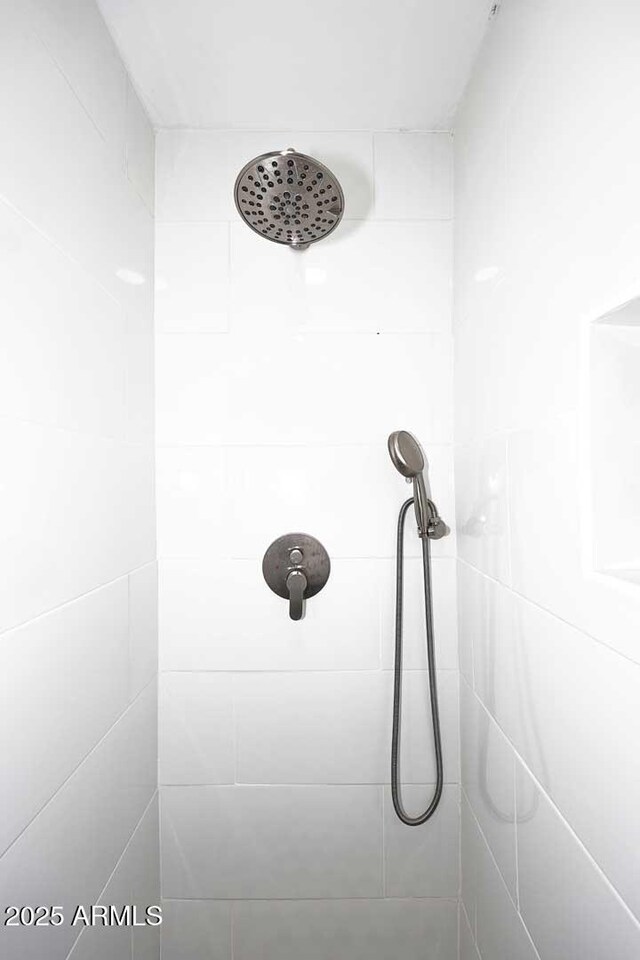 interior details featuring tiled shower