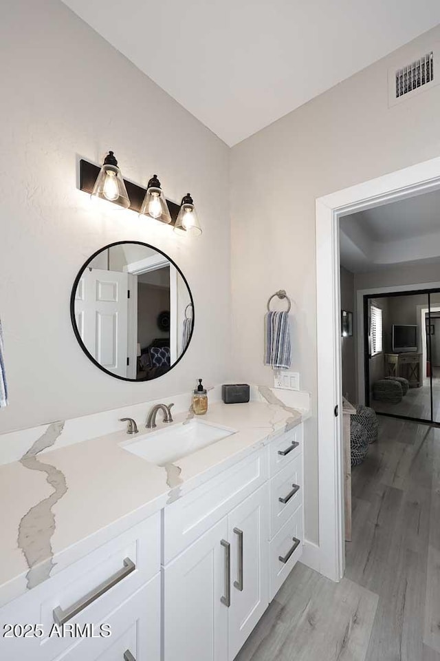 bathroom with visible vents, ensuite bathroom, wood finished floors, and vanity