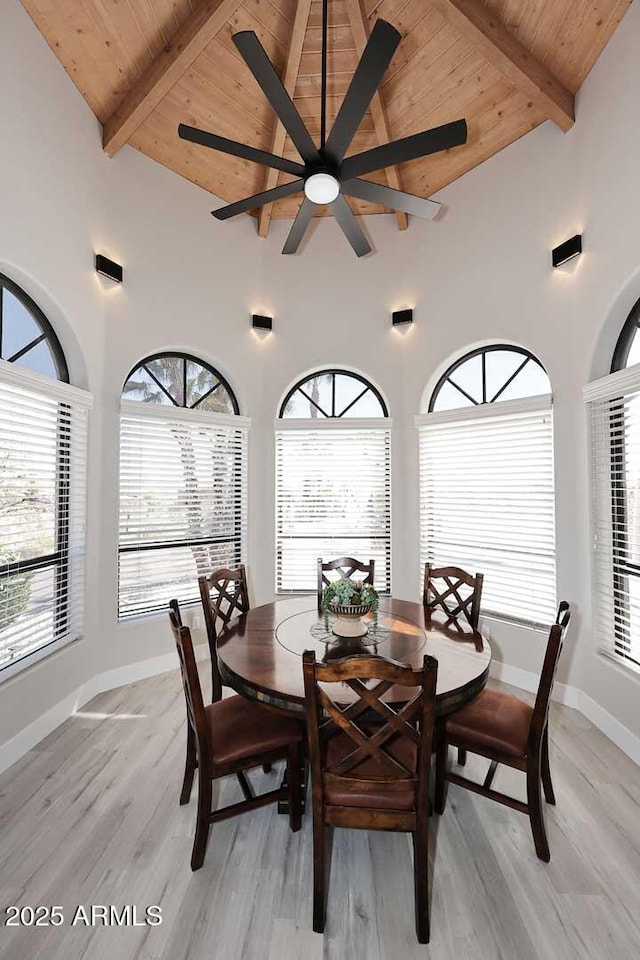 dining room with wooden ceiling, light wood-style floors, and beam ceiling