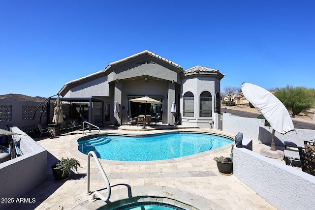 pool with outdoor dining area, an in ground hot tub, and a patio area