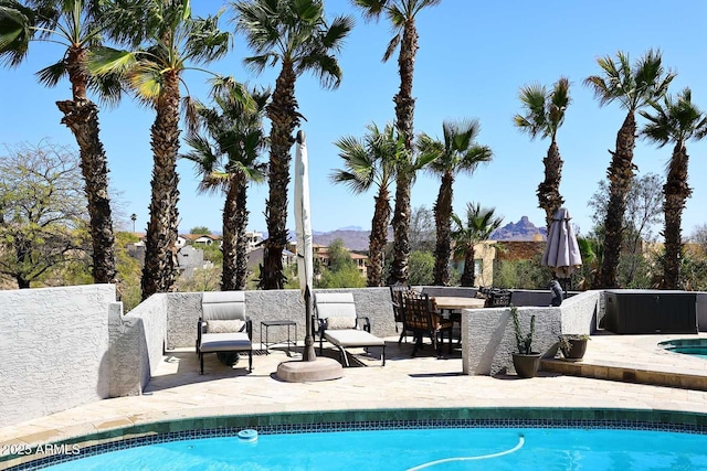 outdoor pool featuring a mountain view and a patio