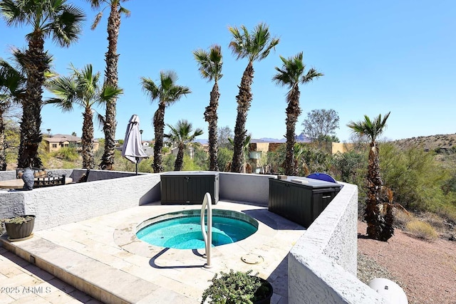 view of pool with a patio area and an in ground hot tub