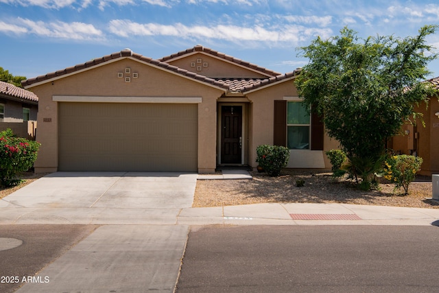 view of front facade featuring driveway, stucco siding, a tile roof, and an attached garage