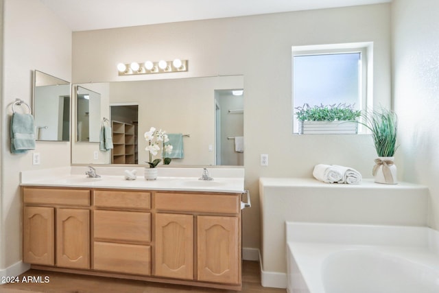 bathroom featuring wood-type flooring, vanity, and a bathtub