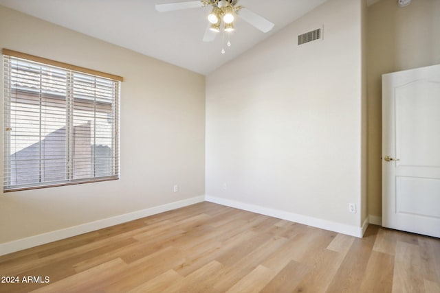 empty room with ceiling fan, vaulted ceiling, and light wood-type flooring