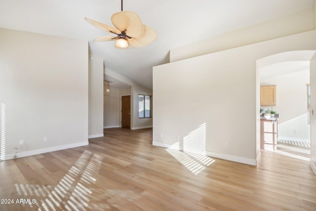 unfurnished room with ceiling fan, lofted ceiling, and light wood-type flooring