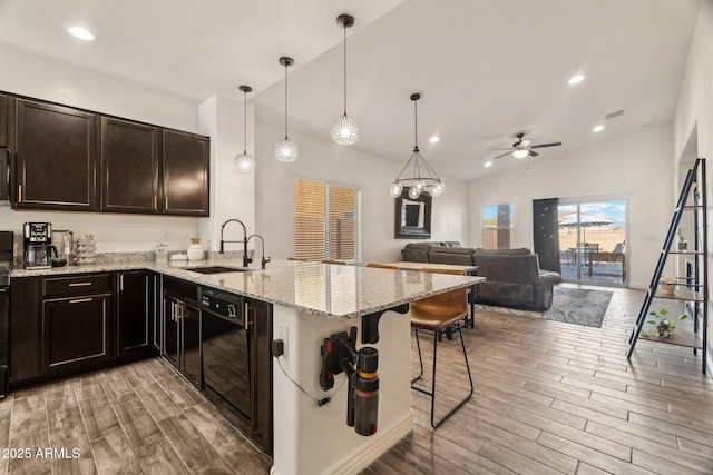 kitchen with lofted ceiling, sink, decorative light fixtures, a kitchen breakfast bar, and kitchen peninsula