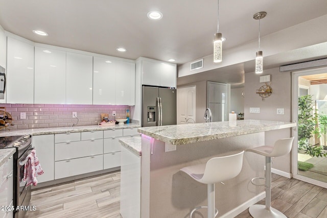 5913 E Thomas Rd, Scottsdale, AZ 85251 - kitchen with stainless steel appliances, modern cabinets, light wood-type flooring, white cabinets, and recessed lighting