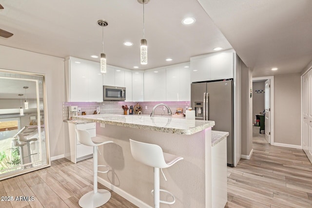 5913 E Thomas Rd, Scottsdale, AZ 85251 - kitchen featuring appliances with stainless steel finishes, modern cabinets, white cabinets, light wood-style flooring, and recessed lighting