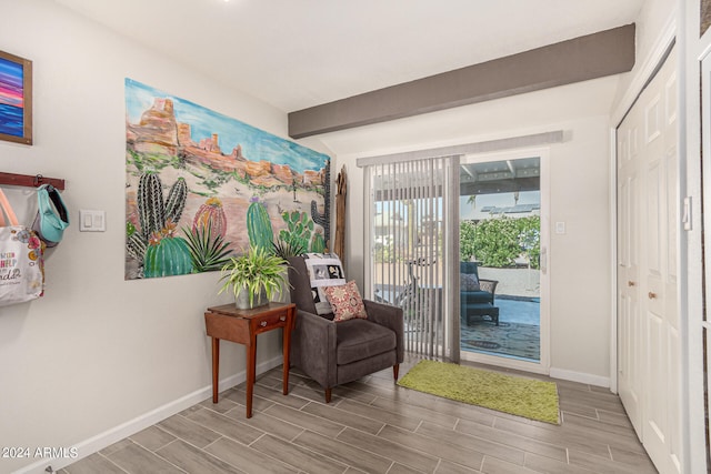 sitting room featuring light hardwood / wood-style floors and beamed ceiling