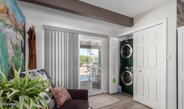 interior space featuring light hardwood / wood-style flooring, beam ceiling, and stacked washer / drying machine