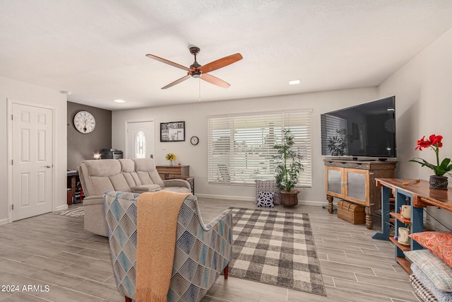 living room featuring light hardwood / wood-style flooring and ceiling fan