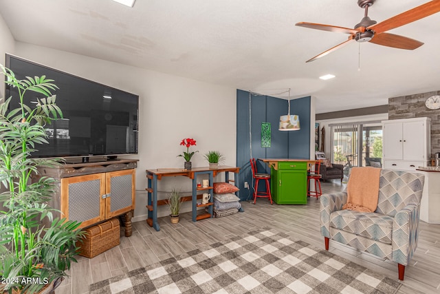 living room with light hardwood / wood-style floors and ceiling fan