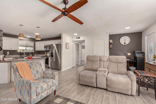 living room featuring light hardwood / wood-style flooring and ceiling fan