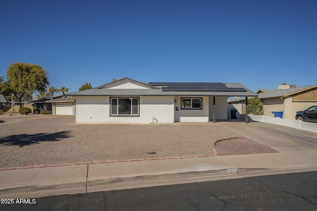 single story home featuring a garage and solar panels