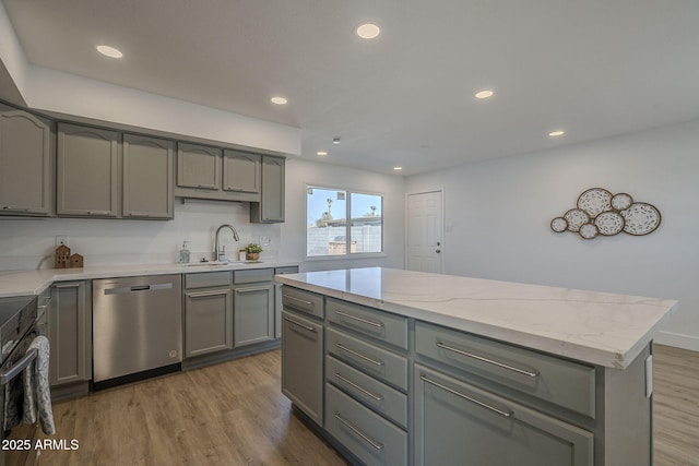 kitchen featuring sink, gray cabinetry, a center island, dishwasher, and hardwood / wood-style floors