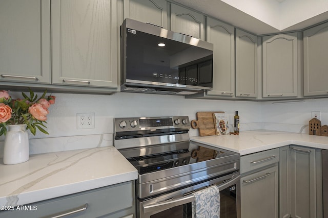 kitchen featuring appliances with stainless steel finishes, gray cabinets, and light stone countertops