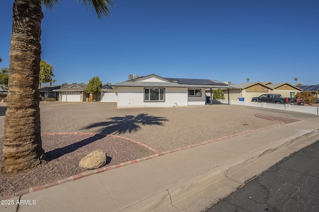 view of front of home with a garage and solar panels