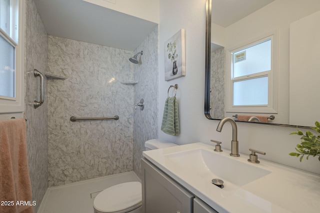 bathroom featuring vanity, toilet, and a tile shower