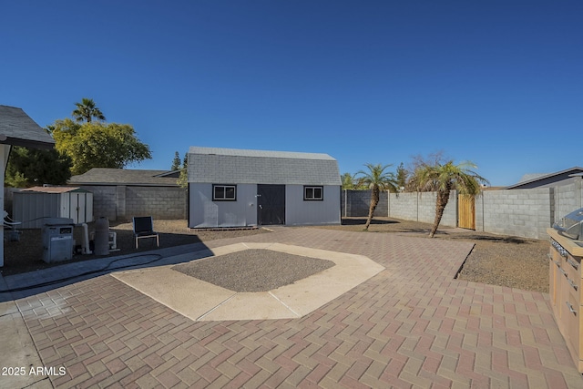 rear view of property featuring a patio and a storage unit