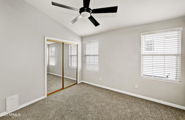 unfurnished bedroom with ceiling fan, baseboards, lofted ceiling, carpet flooring, and a closet