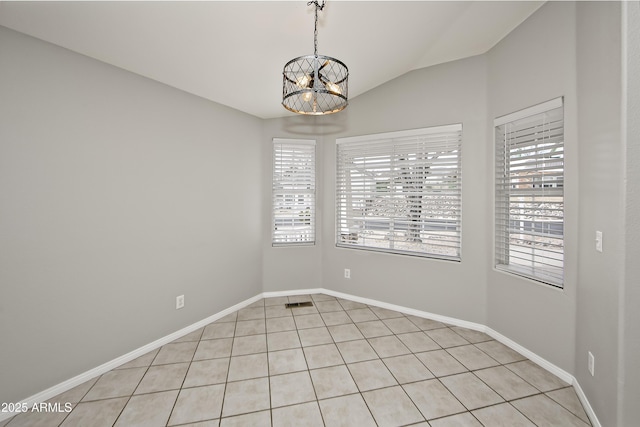 empty room with a notable chandelier, baseboards, and vaulted ceiling