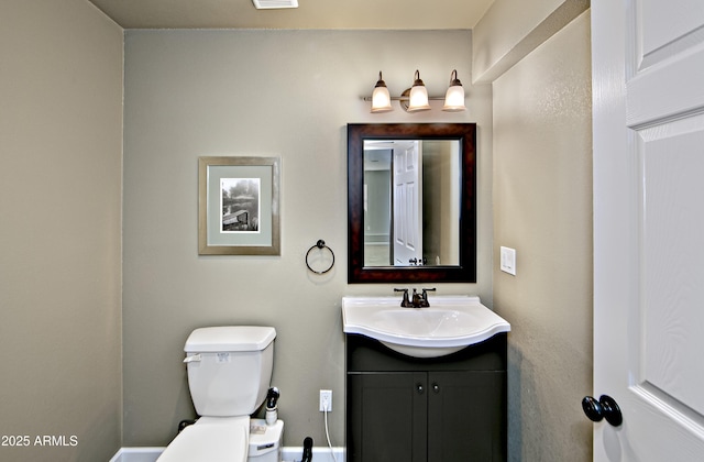 bathroom featuring visible vents, toilet, and vanity