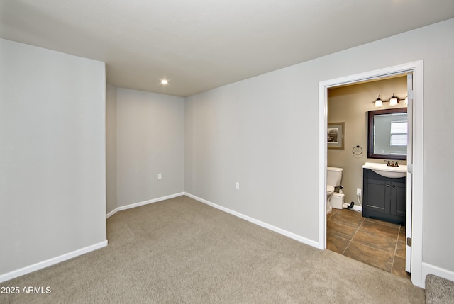 unfurnished bedroom with a sink, recessed lighting, connected bathroom, carpet floors, and baseboards