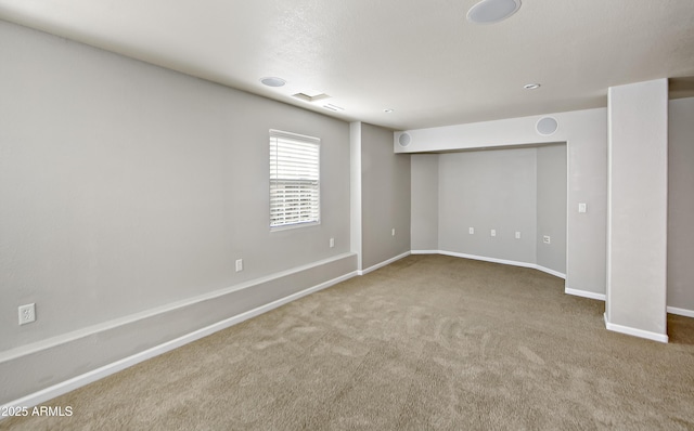 carpeted spare room featuring baseboards