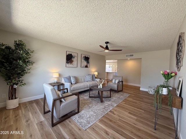 2337 E Manhatton Dr, Tempe, AZ 85282 - living room featuring a textured ceiling, ceiling fan, light wood-style floors, and baseboards