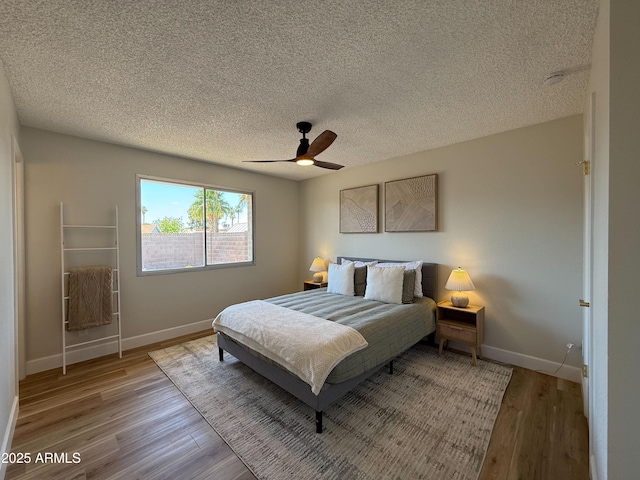 2337 E Manhatton Dr, Tempe, AZ 85282 - bedroom featuring wood finished floors, a textured ceiling, baseboards, and a ceiling fan
