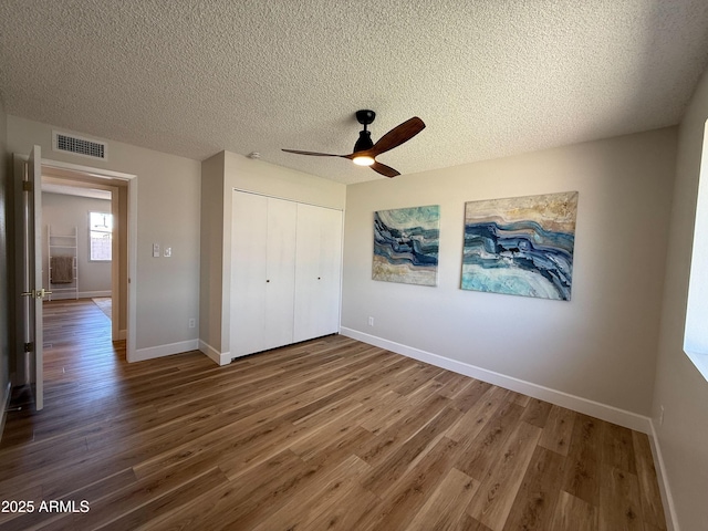 2337 E Manhatton Dr, Tempe, AZ 85282 - unfurnished bedroom featuring wood finished floors, a closet, a textured ceiling, baseboards, and ceiling fan