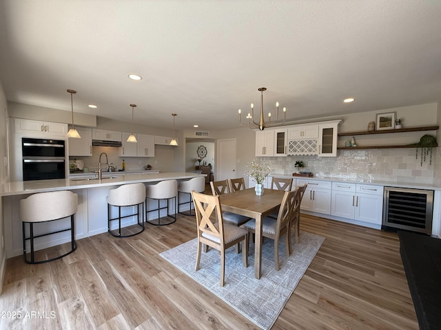 2337 E Manhatton Dr, Tempe, AZ 85282 - dining area with wine cooler, a chandelier, light wood-style floors, recessed lighting, and bar area
