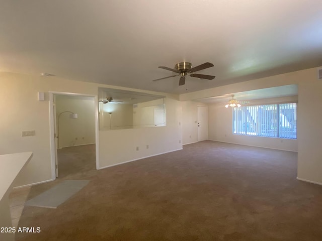 carpeted spare room featuring baseboards and a ceiling fan