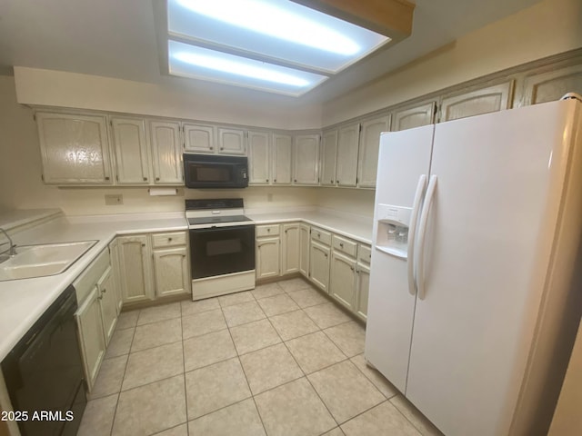 kitchen with light tile patterned floors, black appliances, light countertops, and a sink