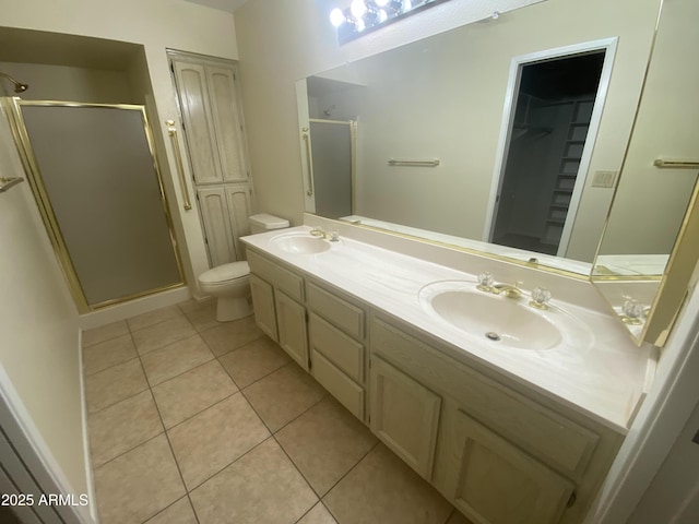 bathroom with tile patterned floors, a stall shower, toilet, and a sink