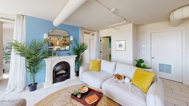 living room with tile patterned floors and a fireplace with raised hearth