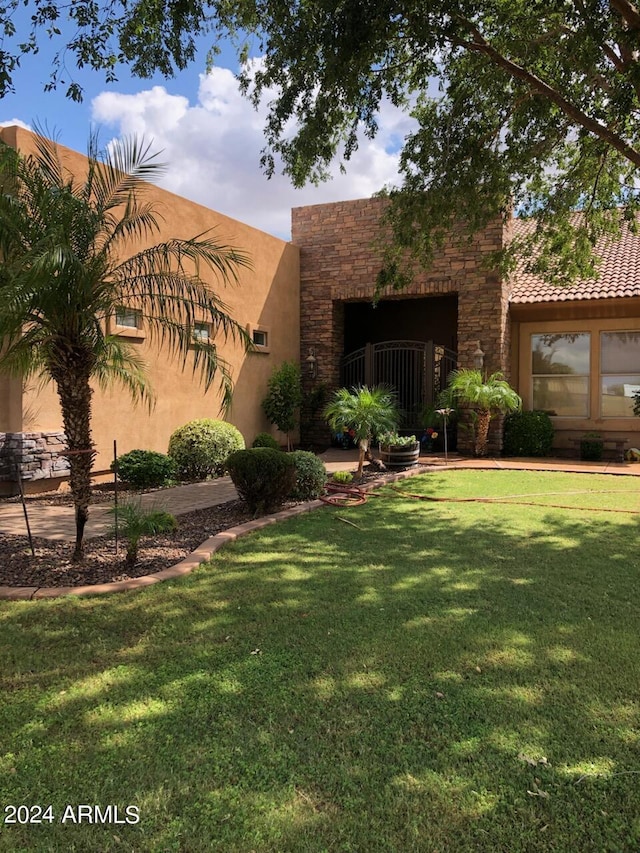 view of front facade with a front yard and stone siding