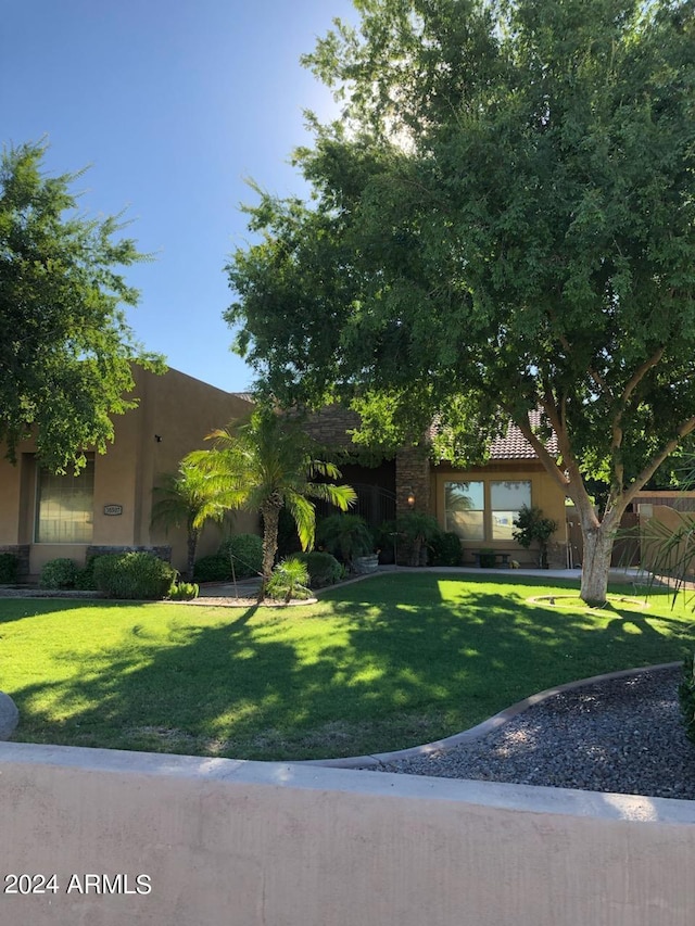 view of front of home with stucco siding and a front lawn
