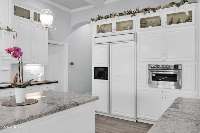 kitchen with white cabinets, decorative light fixtures, and stainless steel oven