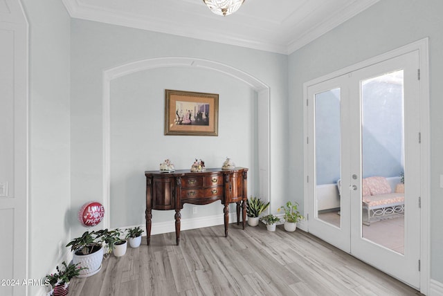 interior space with light hardwood / wood-style floors, crown molding, and french doors