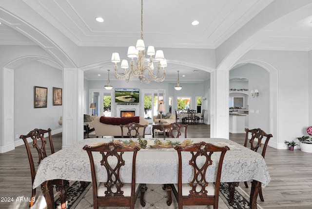 dining space with plenty of natural light, dark hardwood / wood-style floors, ornamental molding, and an inviting chandelier